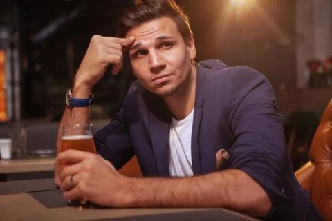 Handsome man drinking beer at the pub Stock Photos
