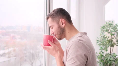 Handsome man drinking coffee and view window Stock Footage 171542832