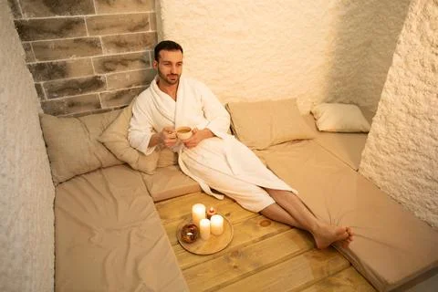 Handsome man drinking wellness tea and inhaling healthy, salty air at salt ro Fotos de archivo