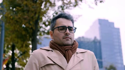 A handsome man of Eastern appearance, a poet and artist, walks down the street Stock Footage 142352709