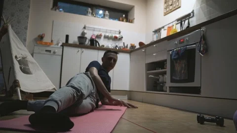 Handsome Man Exercising and Doing Push ups in The Kitchen at Home Stock Footage 107925399