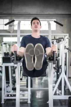 Handsome man exercising arm on machine builder muscles in fitness gym Stock-Fotos