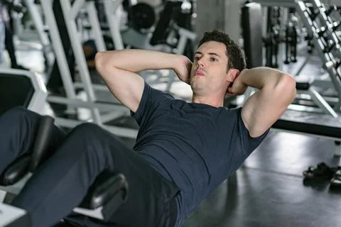 Handsome man exercising doing sit up abdominal exercise in gym Foto stock