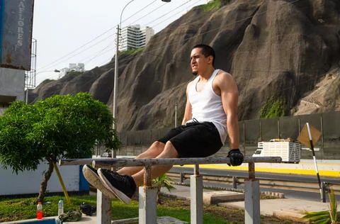 Handsome man exercising on parallel bars on the street outdoors. Stock-Fotos