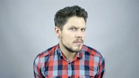 Handsome man expressing doubt over grey background Stockbeeldmateriaal 41795385