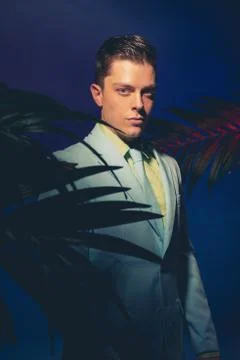 Handsome Man in Formal Wear Between Palm Leaves Stock Photos