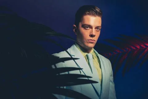 Handsome Man in Formal Wear Between Palm Leaves Stock Photos