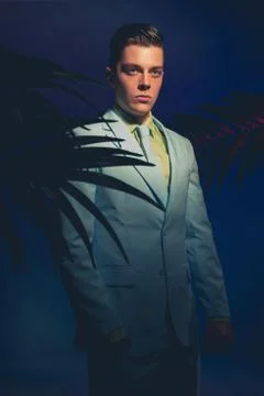 Handsome Man in Formal Wear Between Palm Leaves Stock Photos