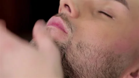 Handsome man getting his beard shaved in a barber shop Stock Footage 252660979