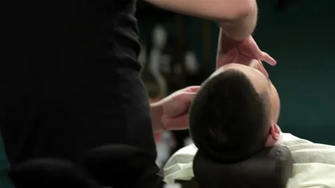 Handsome man getting his beard shaved in a barber shop Stock Footage 252661151