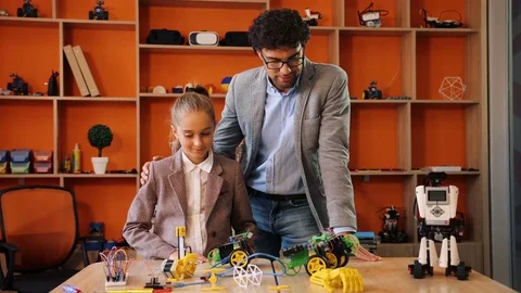 Handsome man with a girl posing to the camera with their mastered robots and Stock Footage 82475911