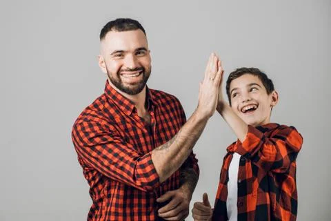 Handsome man giving high five to his son on white background Stock Photos