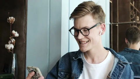 Handsome man with glasses talking via internet with smartphone. Stock Footage 83222240