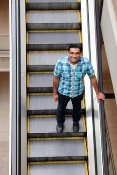Handsome man going down escalator happy Stock Photos