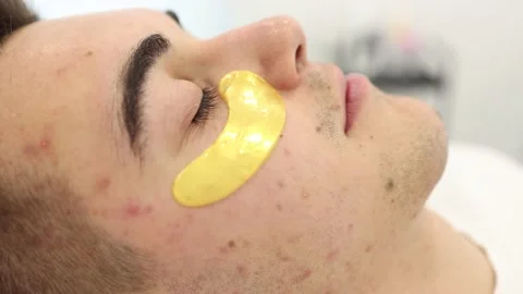 Handsome man with golden patch under eyes. Beauty studio. Spa salon. Close-up Stock Footage 225313460