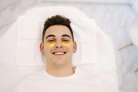 Handsome man with golden patch under eyes. Beauty studio. Spa salon. Top view Stock Photos