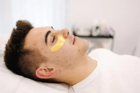 Handsome man with golden patch under eyes. Beauty studio. Spa salon Stock Photos