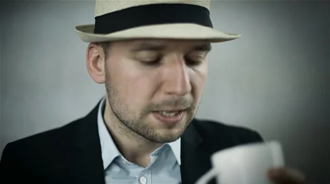 Handsome man in hat drinking coffee/isolated on grey background Видео 39735322