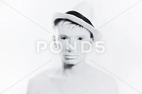 Handsome man in hat with white make-up Stock Photos