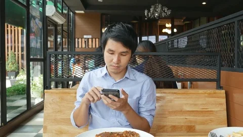 Handsome man having breakfast and using mobile phone Stock Footage 77268566