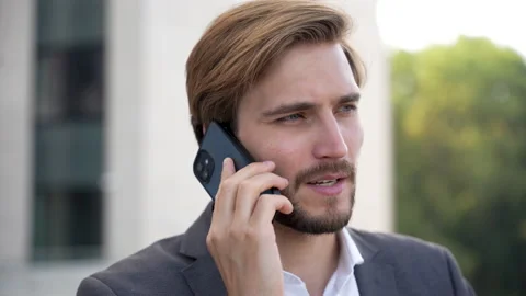 Handsome man having phone talk outdoor. Businessman talking on smartphone Stock Footage 211779536