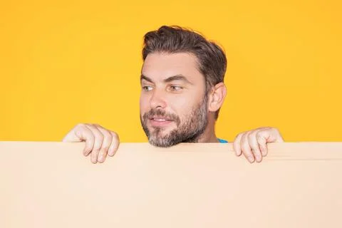 Handsome man holding empty board isolated on studio background. Guy showing Stock Photos