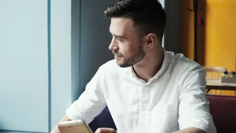 Handsome man at home using smartphone. Stock Footage 77001149