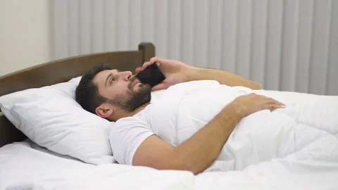 The handsome man lay on the bed and phone. Real time capture Video stock 71964712