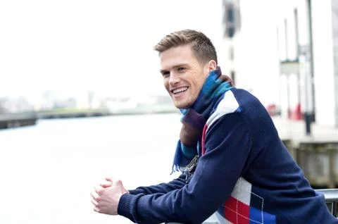 Handsome man leaning on railing at river Stock Photos