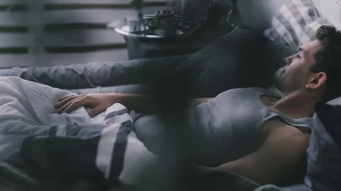 Handsome man lies in bed Video stock 76509938