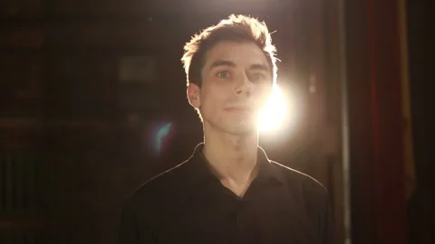 Handsome man looking at camera against backlight background Stock Footage 127512076