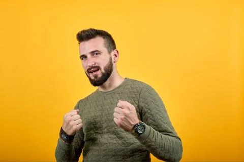 Handsome man looking at camera, keeping fists up, fight, winner gesture 스톡 사진