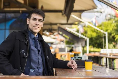 Handsome man looking at camera while smiling after drinking a coffee at a bar Stock Photos