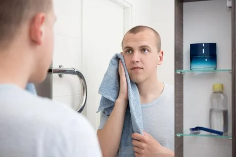 Handsome man  looking at mirror after shaving in bathroom Stockfoto's