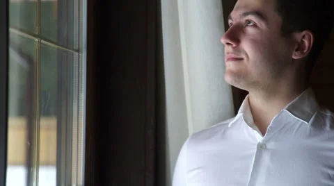 Handsome man looking out the window Video stock 60658857