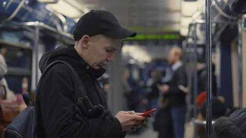 Handsome man looking on screen smartphone and using mobile app in metro train Stock Footage 86533506