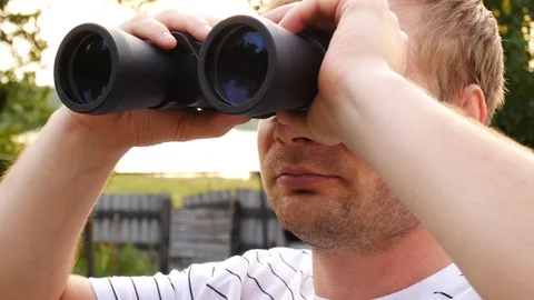 Handsome man looking through binoculars Stock Footage 113184447