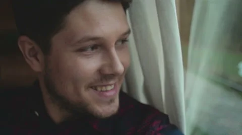 Handsome man looking through a window and smiling. 動画素材 56875724