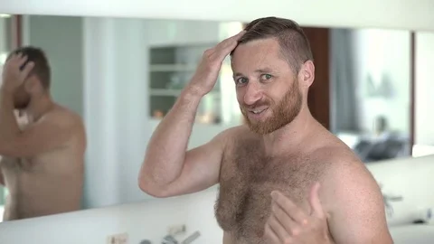 Handsome man looks happy while talking to the camera and checking his appearance 스톡 동영상 81086017