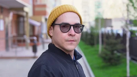 Handsome man looks straight into camera, puts on protective medical face mask Stock Footage 131477199