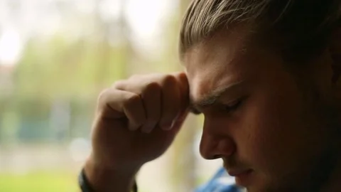Handsome man looks worried while having painful headache, close-up Stock Footage 75134061