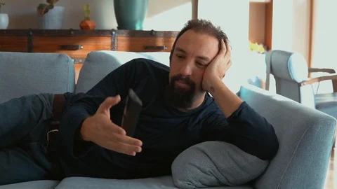 Handsome man lying on the sofa and watching TV Stock Footage 121581467