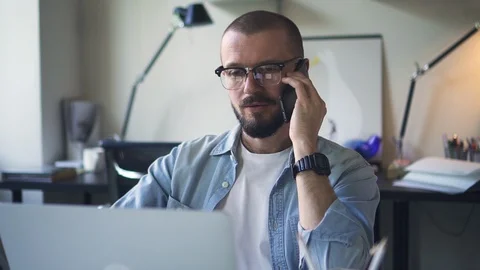 Handsome man manager talking on the phone in office with laptop computer Stock Footage 126703084