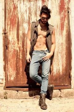 Handsome man model dressed punk, hipster posing dramatic in grun Stock Photos