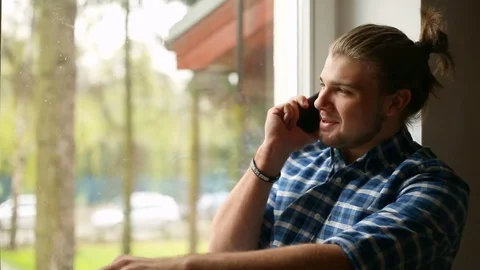 Handsome man with mud bun chatting on cellphone and smiling to the camera Stock Footage 75139154