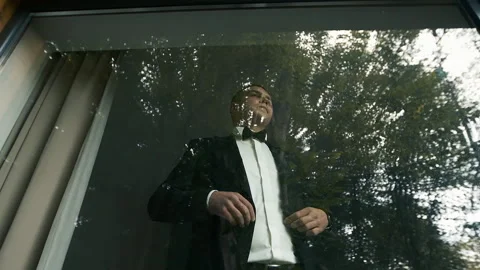 Handsome man near the panoramic window of his house is going to an important Stock Footage 131826516
