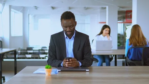 Handsome man office employee using smartphone texting message at workplace Stock Footage 118243775