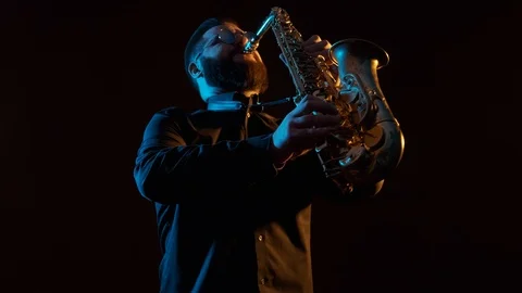 Handsome man playing the saxophone, black background, isolated, solo Vidéo 127054243