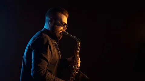 Handsome man playing the saxophone, black background, isolated, solo Stock-Footage 127054412