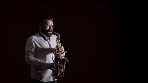 Handsome man playing the saxophone, black background, isolated, solo Video stock 127054541